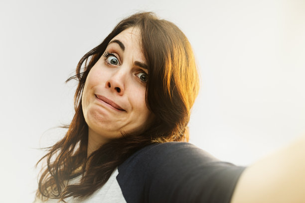 年轻女子做了个鬼脸，还在自拍素材图片