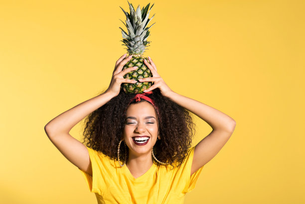 头顶菠萝的快乐年轻非洲裔女子素材图片