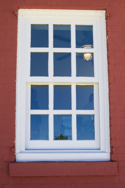 白色的窗户，红色的砖墙，室内的灯光图片下载