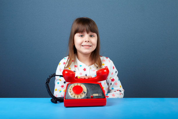 可爱的女孩头顶着旧的红色电话图片下载
