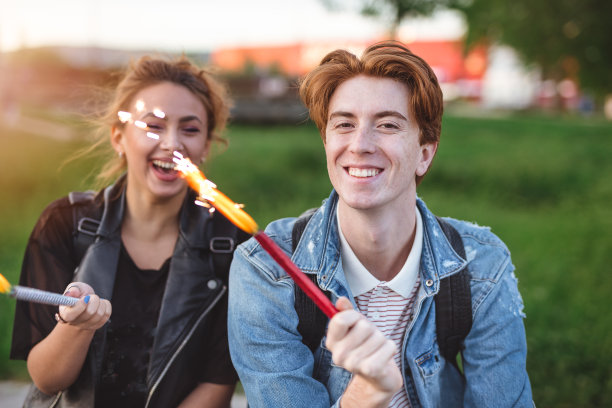 一对红头发的情侣在户外拿着烟花图片下载
