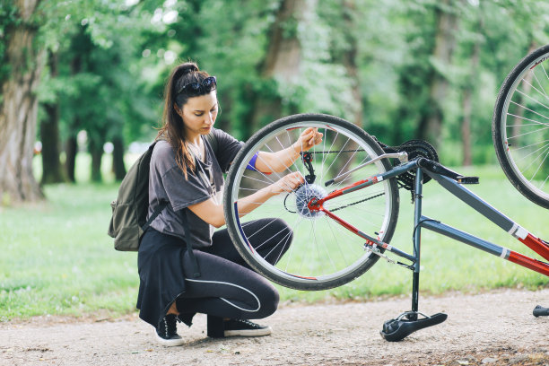 年轻女子正在修理她的自行车图片下载