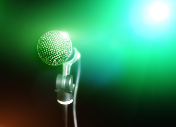麦克风沐浴在舞台灯光的绿色光芒中图片下载