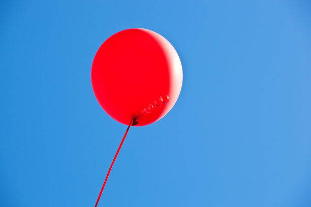 红色的气球在明亮的蓝色天空中飞翔图片下载
