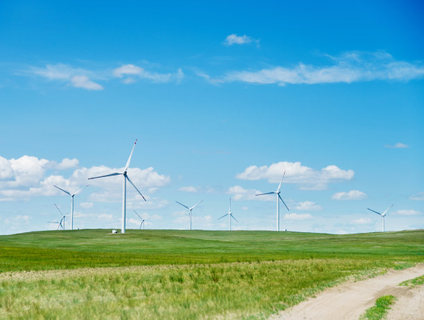 草地上有土路和风力发电机图片下载