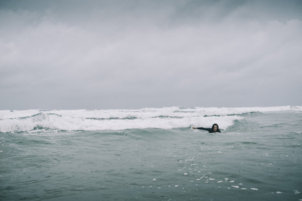 女冲浪者在海上，在阴天冲浪板上。图片下载