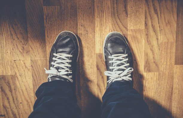 男人的脚放在木地板上图片下载