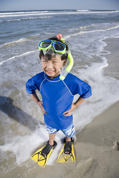 快乐的亚洲男孩在海滩上戴着面罩呼吸管和脚蹼图片下载
