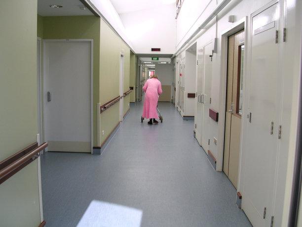 一个女人拄着拐杖独自走在走廊上图片下载