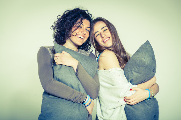 卧室里有两个抱枕头的美女图片下载