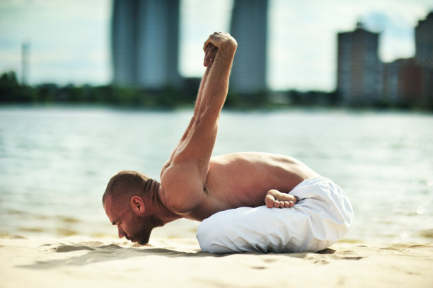 在海滩上做瑜伽的男人图片下载