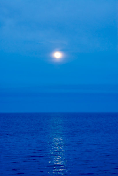 朦胧的月亮在黑暗的水面上图片下载