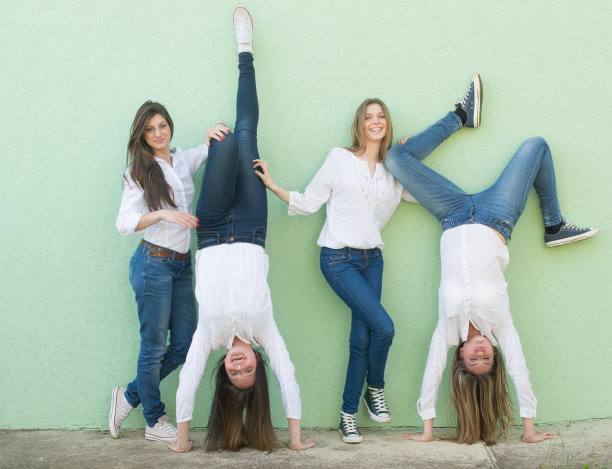四个年轻漂亮的女性朋友靠在墙上摆姿势图片下载