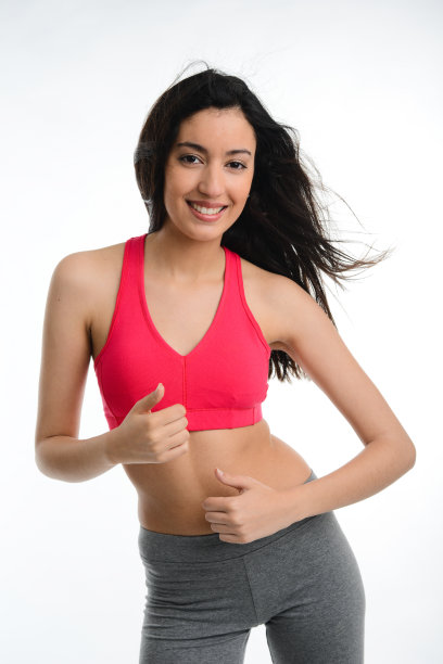 快乐的年轻黑发女子做健身运动，白色背景图片下载