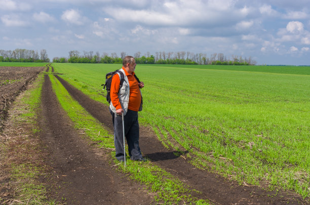 一位老人站在乡间小路上图片下载