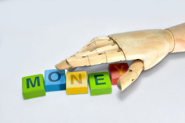 手抓木头的字母是为了在白色的背景上创造钱币。图片下载
