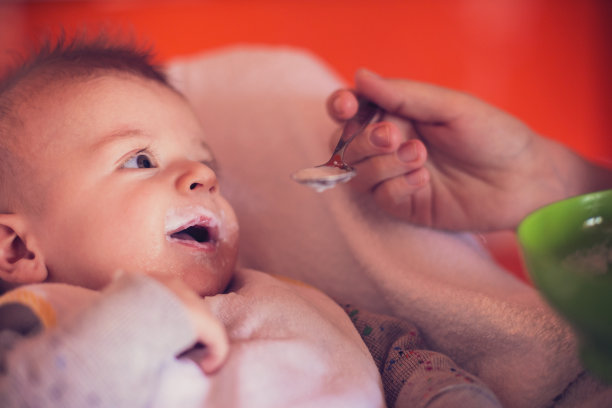 年轻的父亲正在喂养一个可爱的小男孩素材图片