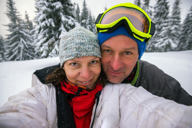 一对快乐的旅行者在冬季的山上自拍图片下载