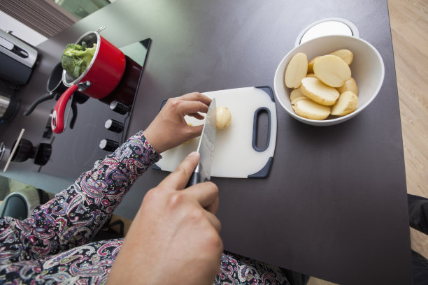 高角度的人切土豆在厨房柜台图片下载