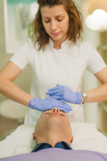 放松的男人正在做面部按摩和脱皮治疗图片下载