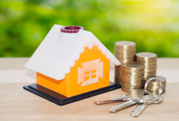 出售和出租房地产贷款的概念。带钥匙和硬币的模型家图片下载