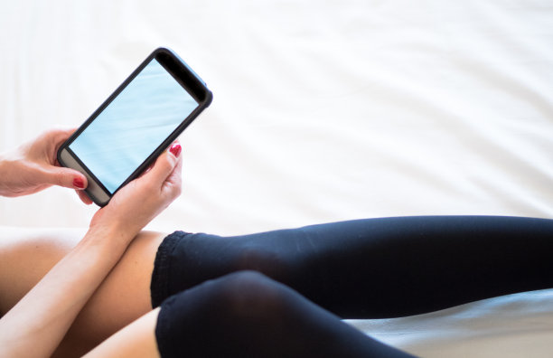 女孩躺在家里的床上用手机图片下载