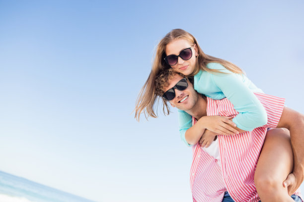 一对幸福的情侣在沙滩上摆姿势图片下载