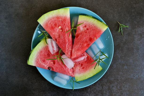 背景的新鲜西瓜片与冰在一个黑色的背景图片下载