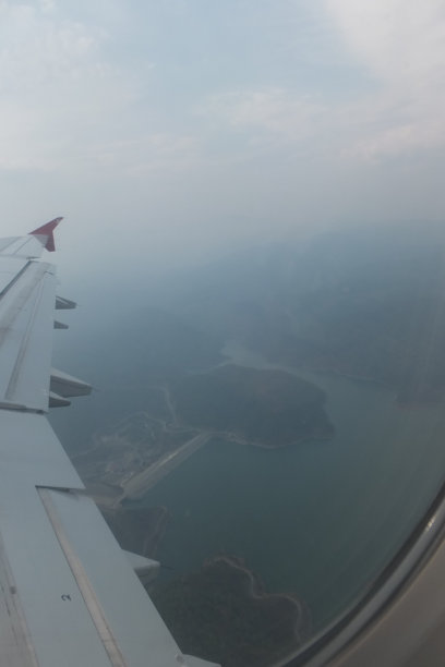 透过飞机窗户俯瞰海面的岛屿景色图片下载