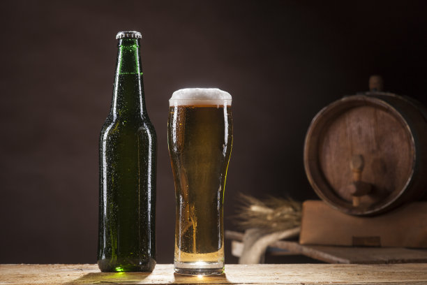 棕色背景的啤酒桶、酒瓶和马克杯图片下载