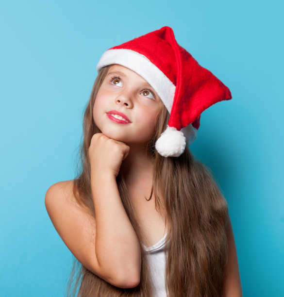 年轻的微笑女孩戴着圣诞老人的帽子图片下载