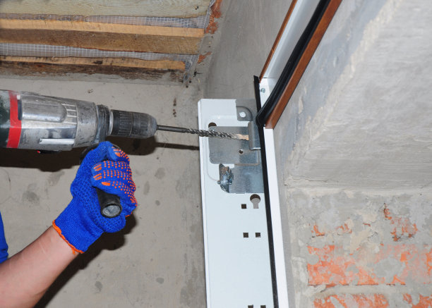 车库门安装和更换。安装车库门并钻孔固定车库门弹簧。图片下载