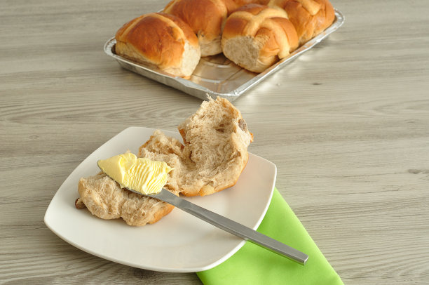 热十字面包，黄油，刀子和绿色餐巾图片下载