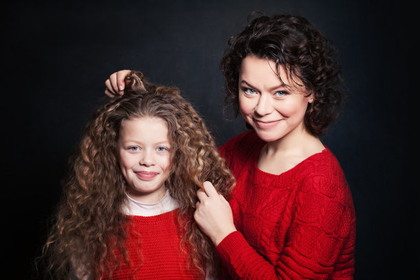 微笑的母亲和女儿长卷发。快乐的女人和孩子图片下载