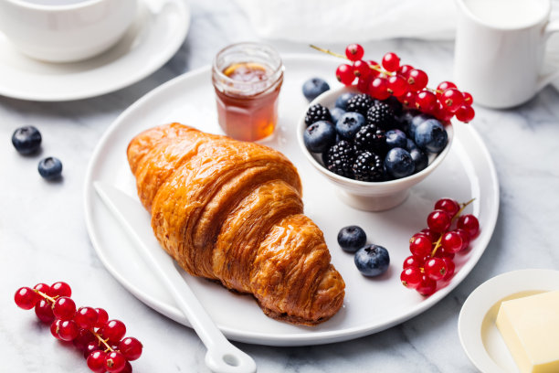 大理石纹理背景上的新鲜浆果和黄油牛角面包。俯视图图片下载