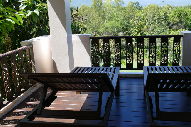 阳台上的木制躺椅，可以看到森林和天空图片下载