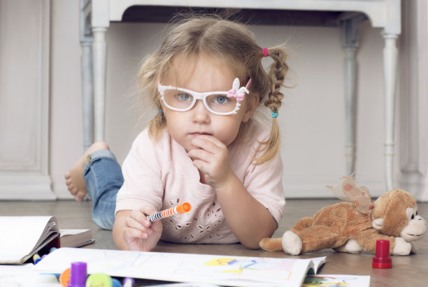 一个戴着眼镜和马克笔的孩子的肖像。图片下载