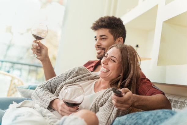 一个年轻夫妇在家里享受葡萄酒的特写素材图片