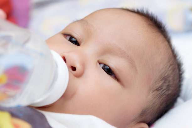 婴儿用奶瓶喝牛奶图片下载