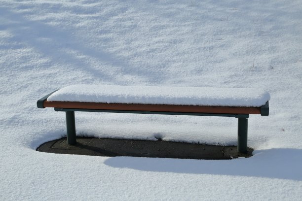 纯白的雪堆在长凳上。图片下载