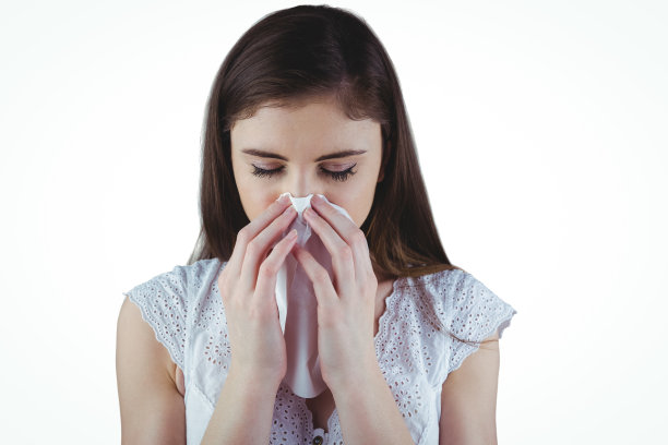 生病的黑发女人在擤鼻子图片下载