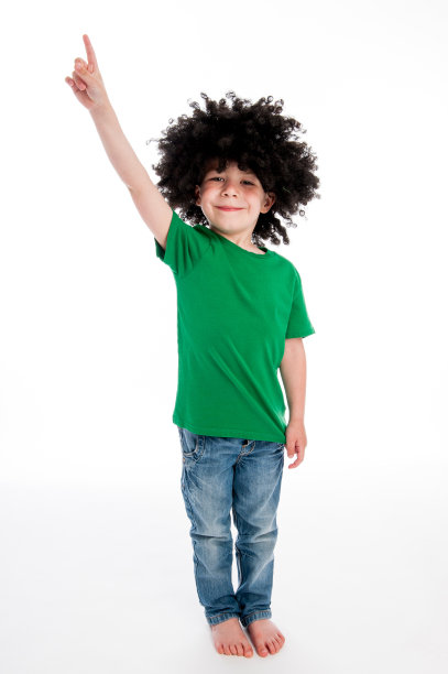 戴着黑色假发的男孩指着天空。图片下载