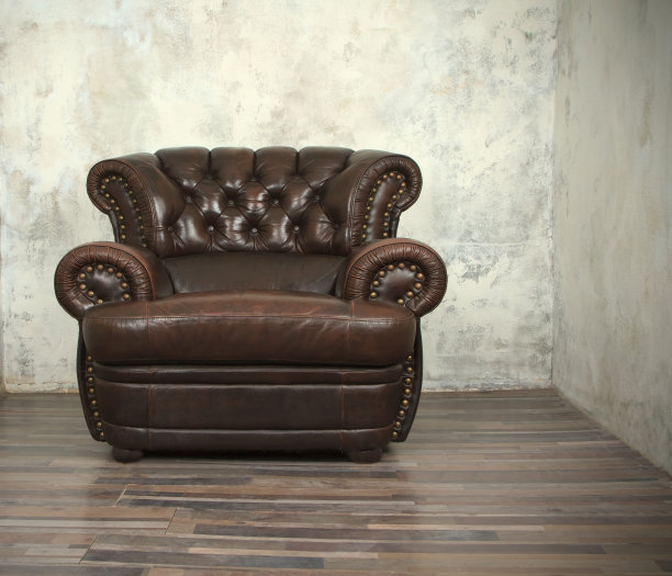 空房间里的老式棕色皮革椅子图片下载