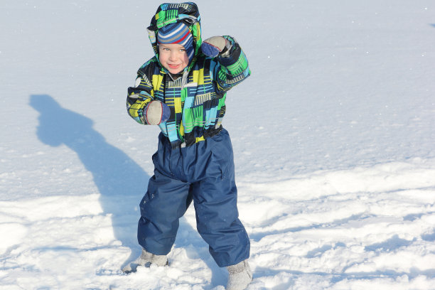 小男孩站在一个对抗雪的架子上图片下载