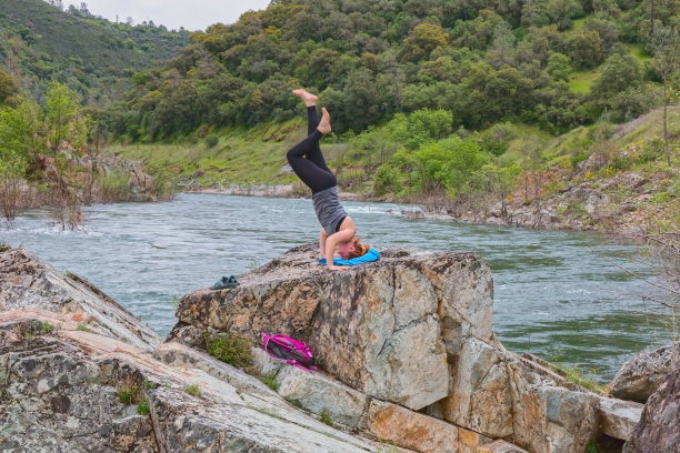 女孩试图在法特河附近的岩石上做倒立图片下载