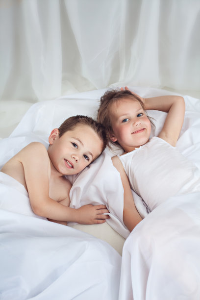 可爱的小弟弟和小妹妹躺在床上图片下载