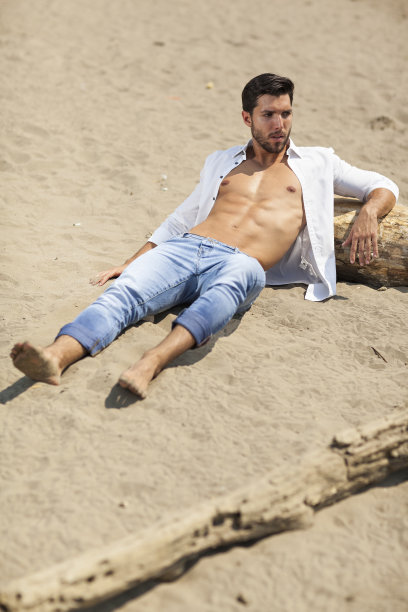 海滩上的年轻性感男人，有选择性的专注图片下载