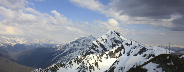 全景，多云天气下从山顶俯瞰。蓝雾中的山谷和积雪的山脉。图片下载