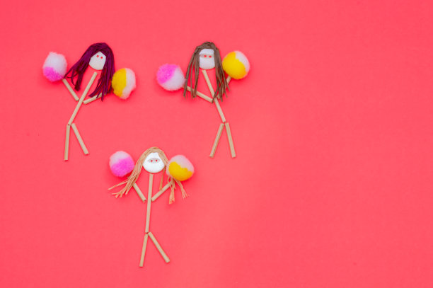 拉拉队长纽扣头棒状女孩粉色和黄色绒球图片下载