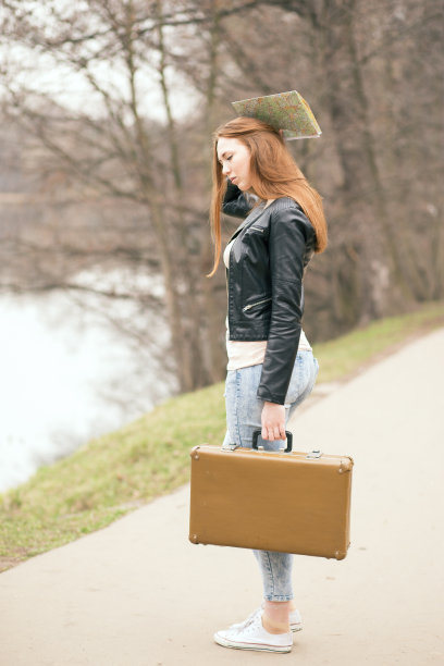 女人拿着旅行箱和路线图站在路上图片下载